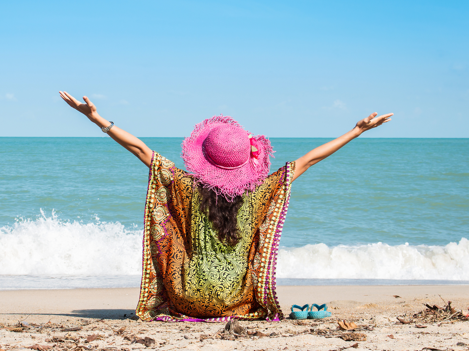 A woman raising her hands, surrounded by sunflowers.